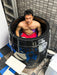 A man inmersed in a cold plunge ice barrel